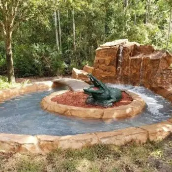 Stone pool waterfall alligator statue