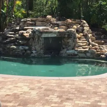Stone pool waterfall brick patio