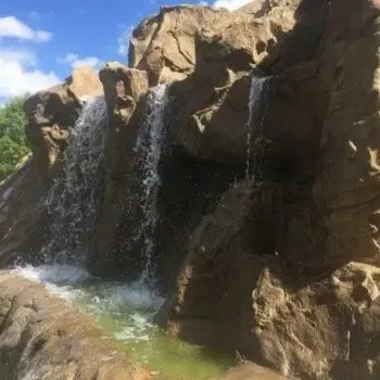 Artificial waterfall near concrete pool