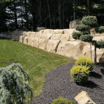 Landscaped backyard with stone wall