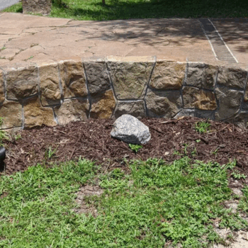 Stone wall concrete driveway landscaping